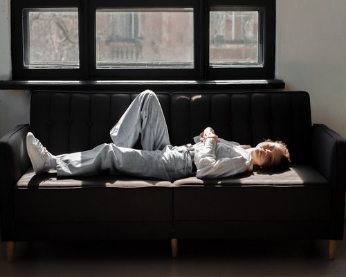 A person resting comfortably on a sofa after a long day of work